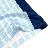 Detail shot of custom soccer jersey hem and side panel, showing light blue striped and navy fabric with stitching.
